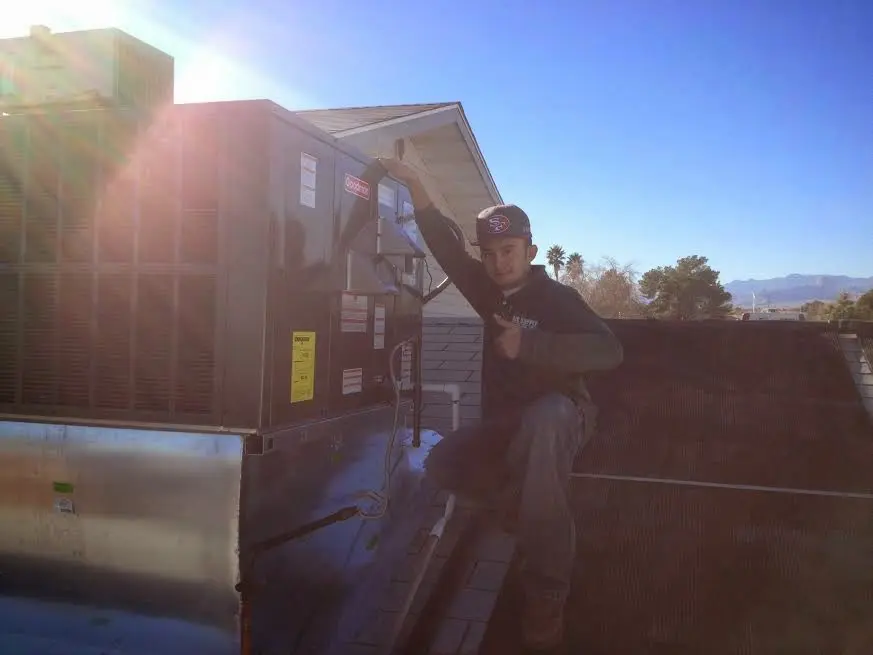 HVAC technician performing Boiler Repair on a rooftop unit in Senoia